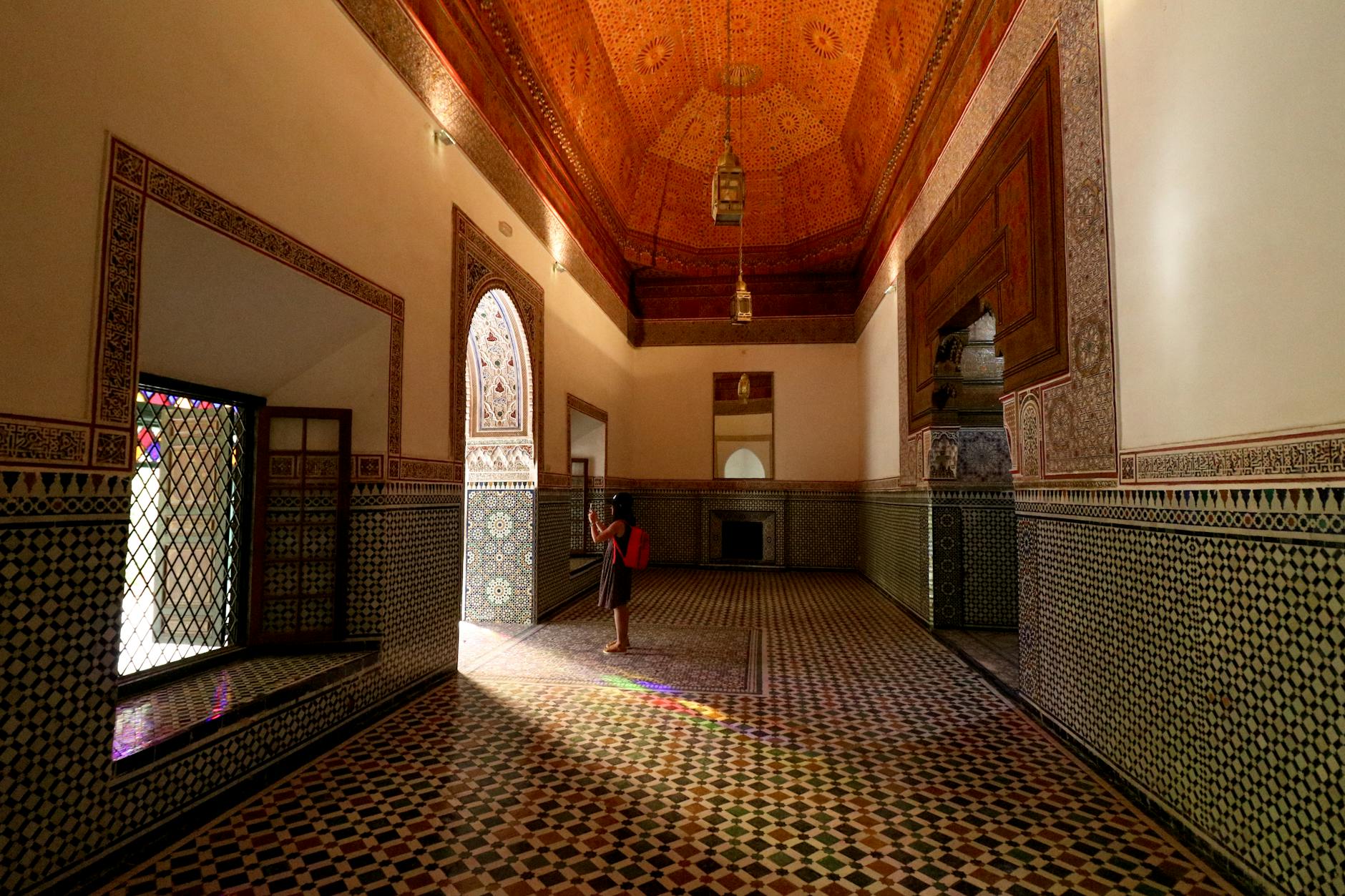 a girl standing at the hallway of bahia palace in marrakech morocco