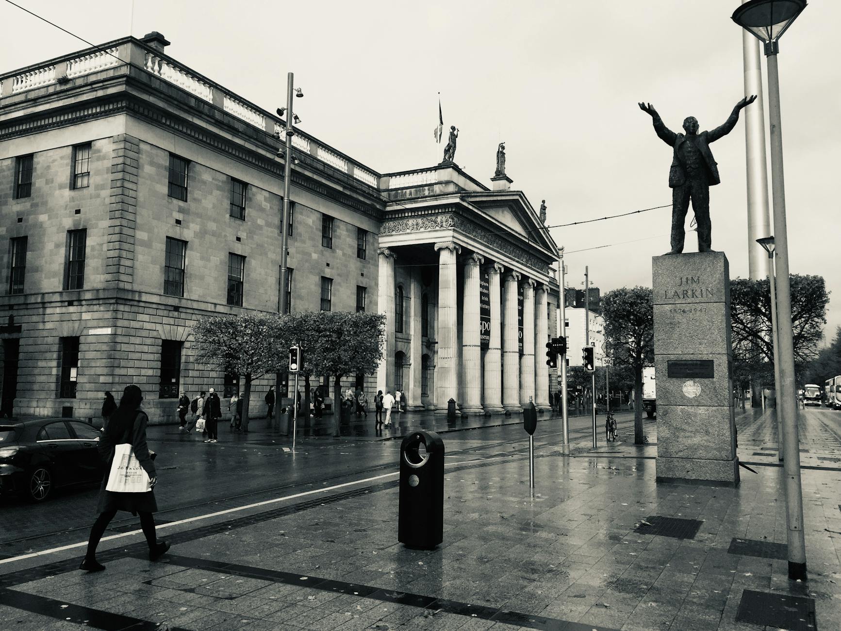 grayscale photo of people walking on street near gpo museum