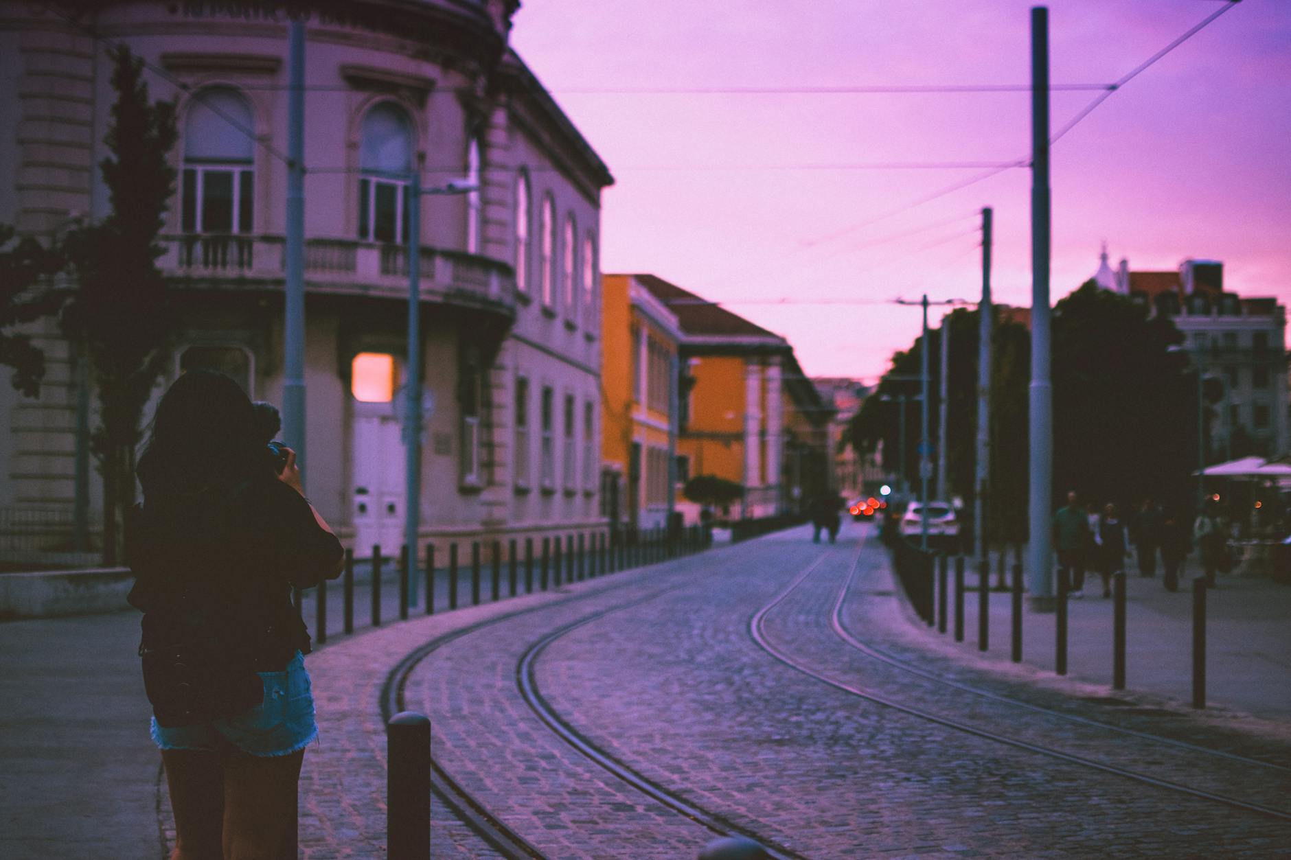 woman standing beside road during golden hour